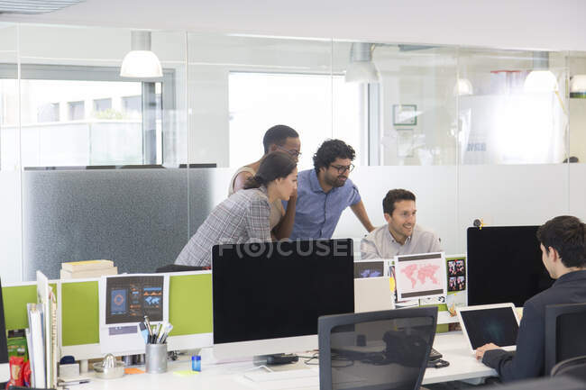 Reunión de empresarios en el ordenador en la oficina de planta abierta - foto de stock
