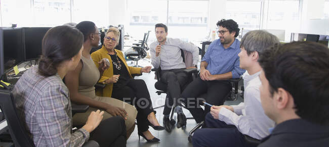 Деловые люди разговаривают, встречаются в офисе открытого плана — стоковое фото