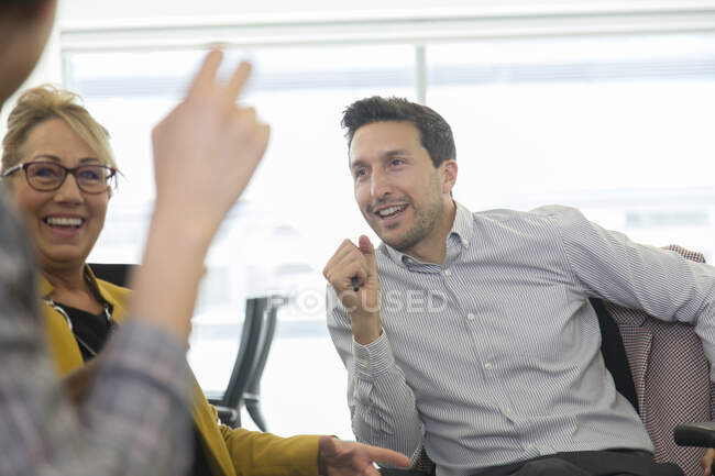 Gli uomini d'affari sorridenti che parlano in riunione — Foto stock