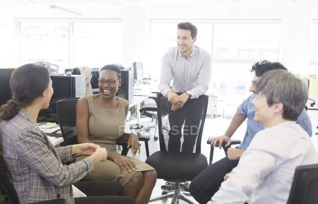 Des gens d'affaires heureux parlent, se rencontrent dans un bureau décloisonné — Photo de stock