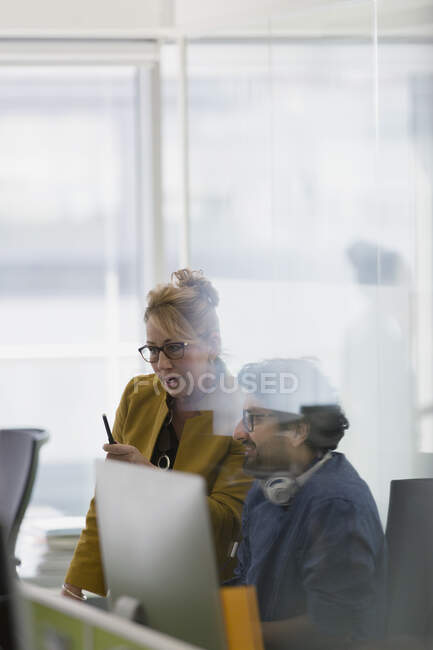 Gente de negocios hablando, reuniéndose en la computadora en la oficina - foto de stock