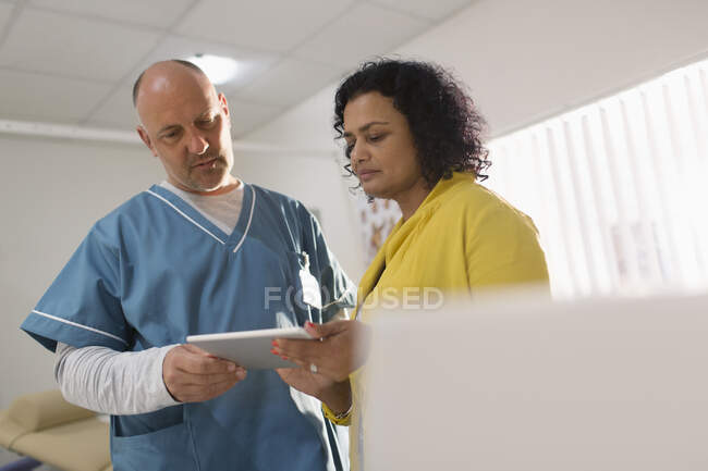 Doctors with digital tablet meeting in doctors office — Stock Photo