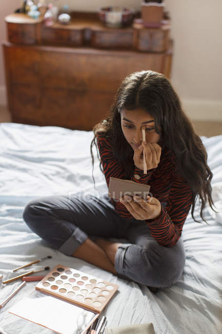 Teenager-Mädchen trägt Lidschatten-Make-up auf Bett auf — Stockfoto