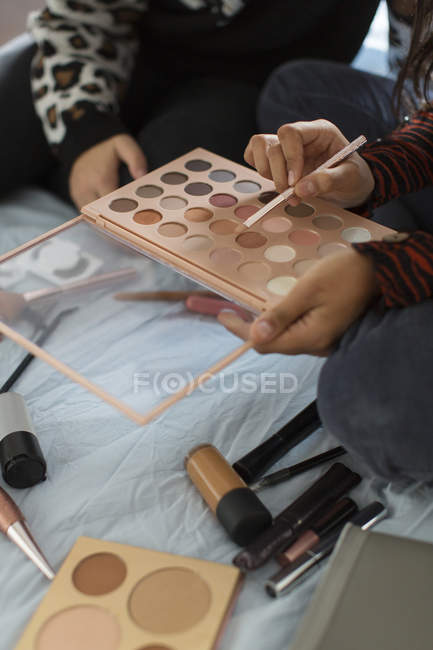 Close up teenage girls with eyeshadow makeup palette — Stock Photo