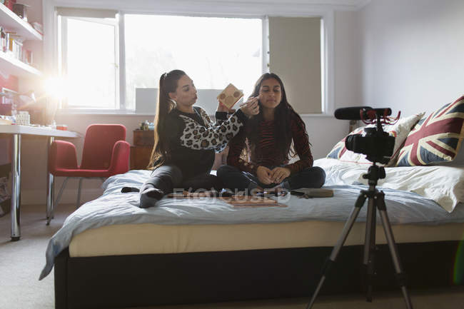 Девочки-подростки делают видеоблог, демонстрируют макияж на кровати — стоковое фото