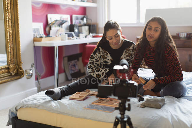 Teenage girls with makeup vlogging on bed — Stock Photo