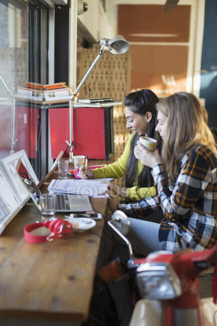 Jovens estudantes universitárias estudando na janela do café — Fotografia de Stock