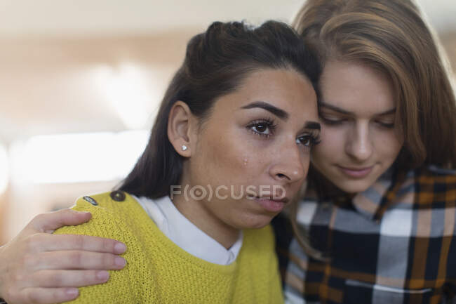 Молода жінка втішає плачучого друга. — стокове фото