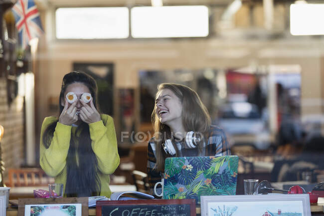 Portrait playful young female college students studying in cafe window — Stock Photo