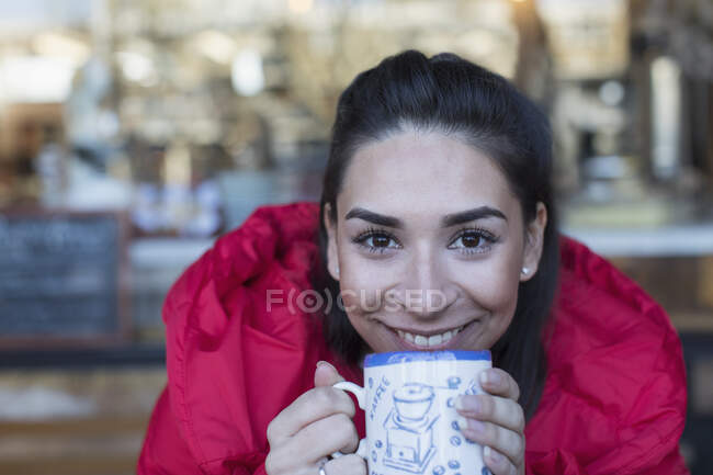 Крупним планом портрет щасливої молодої жінки, що п'є каву — стокове фото