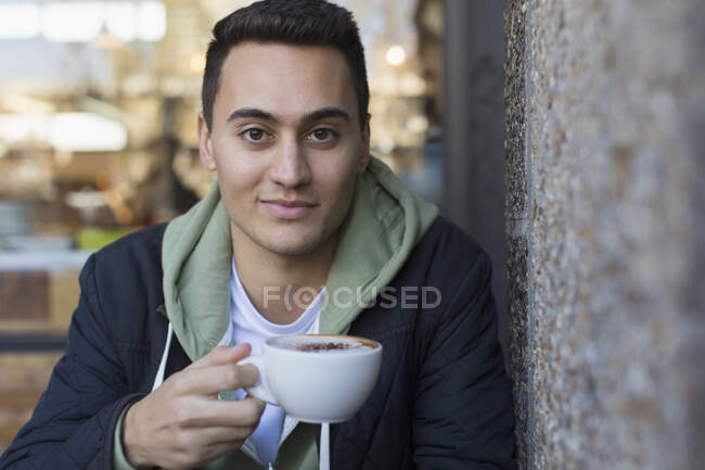 Retrato confiante jovem bebendo cappuccino — Fotografia de Stock