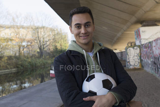 Портрет уверенный молодой человек с футбольным мячом — стоковое фото