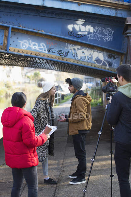 Étudiants de cinéma collégial filmant sous un pont urbain — Photo de stock