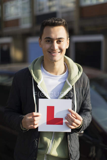 Portrait happy, confident young man holding learner permit — Stock Photo