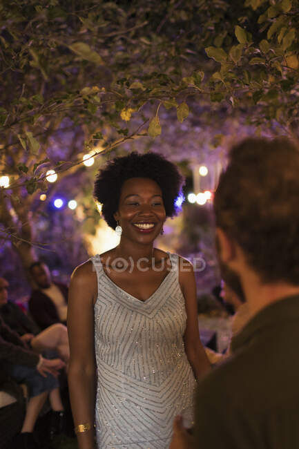 Щаслива молода жінка розмовляє з чоловіком на садовій вечірці — стокове фото