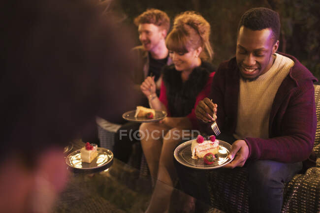 Friends celebrating birthday, eating cake on patio — Stock Photo