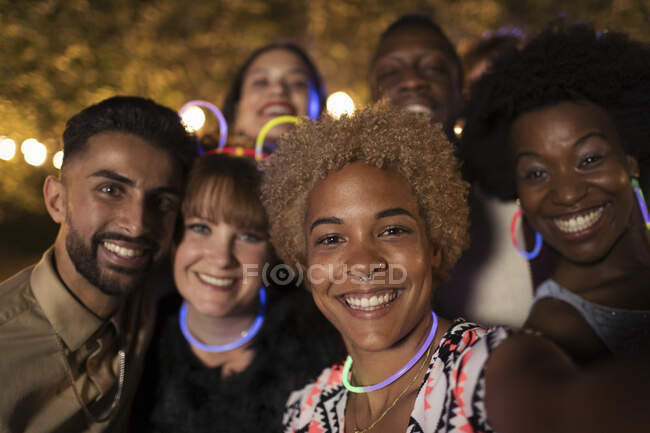 Portrait happy friends wearing neon at party — Stock Photo