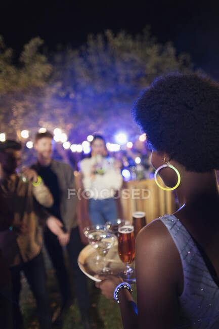 Молодая женщина, подающая коктейли на вечеринке в саду — стоковое фото
