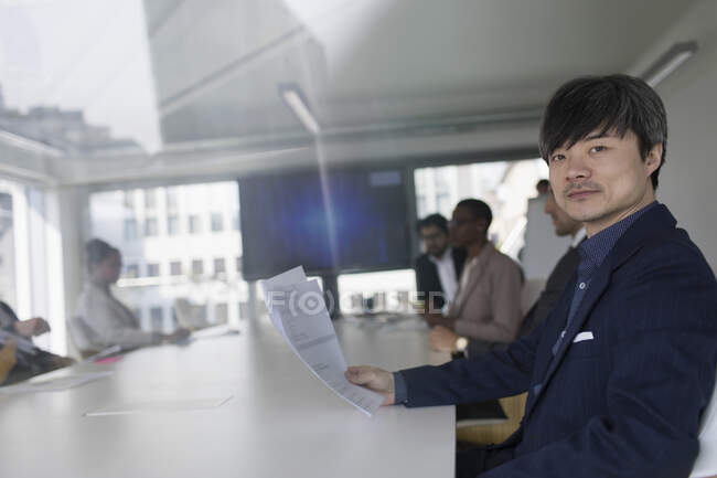 Porträt selbstbewusster Geschäftsmann überprüft Papierkram im Konferenzraum — Stockfoto
