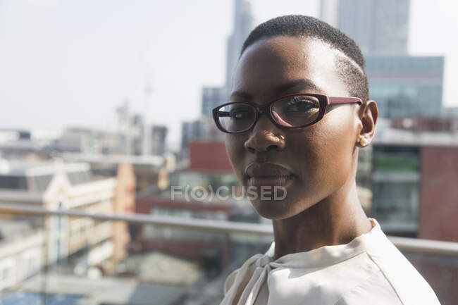 Close up retrato confiante empresária no ensolarado, varanda highrise urbano — Fotografia de Stock
