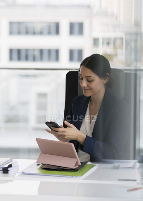 Businesswoman using smart phone in conference room — Stock Photo