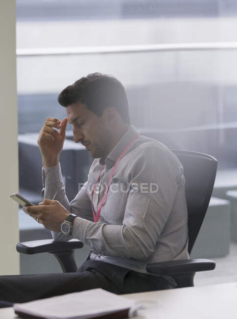 Empresário usando telefone inteligente no escritório — Fotografia de Stock