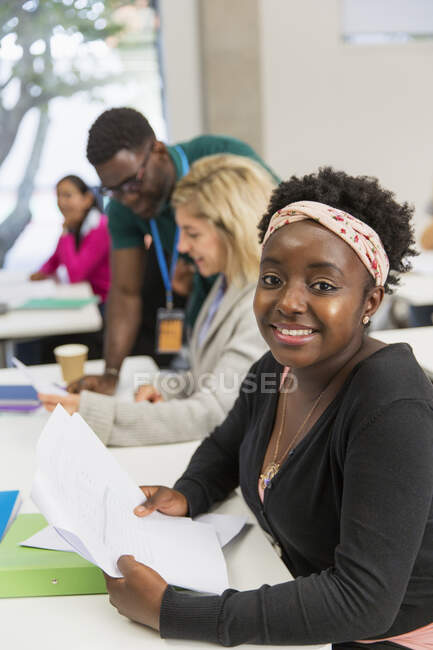 Portrait confident female student with paperwork in classroom — Stock Photo