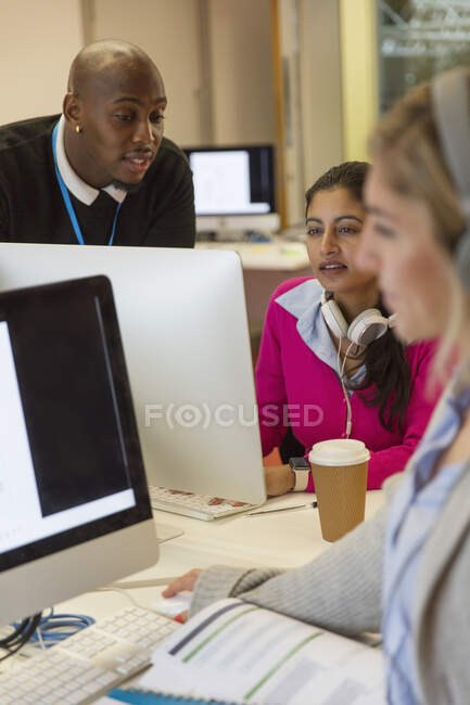 Estudiantes trabajando en computadoras en el aula - foto de stock