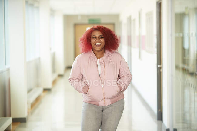 Portrait enthusiastic female high school student in corridor — Stock Photo