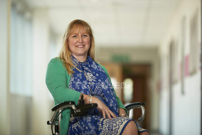 Retrato mulher confiante em cadeira de rodas no corredor — Fotografia de Stock
