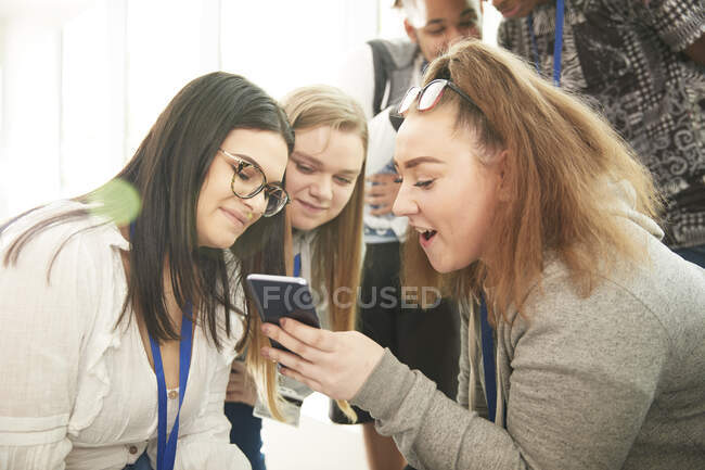 Amis de lycéenne utilisant le téléphone intelligent — Photo de stock