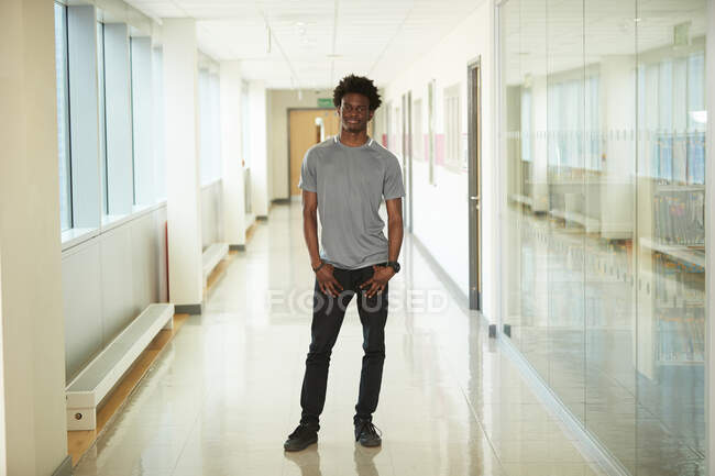 Ritratto fiducioso studente di college maschile in corridoio — Foto stock