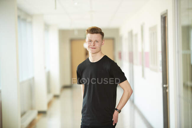 Portrait confident high school boy in corridor — Stock Photo