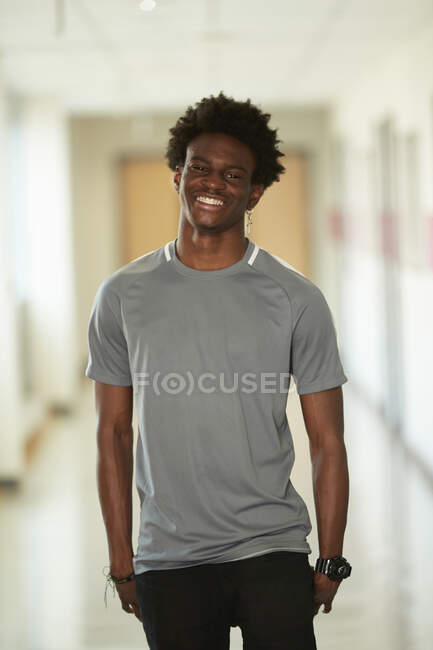 Retrato confiante feliz menino do ensino médio no corredor — Fotografia de Stock