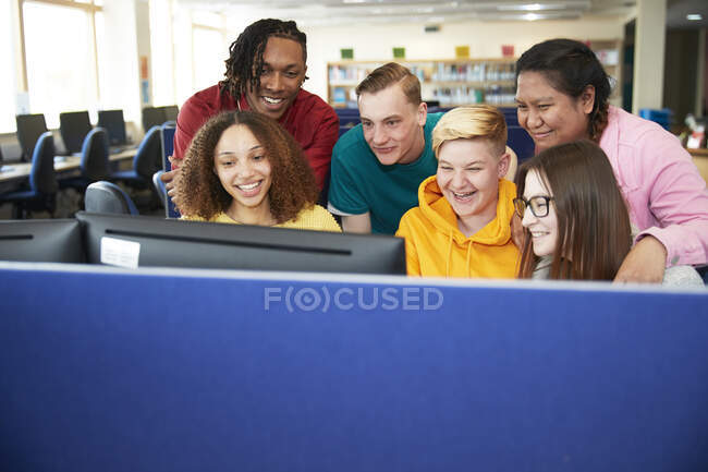 High school students using computer in library — Stock Photo