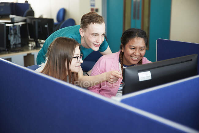 Estudiantes universitarios usando computadora en el aula - foto de stock