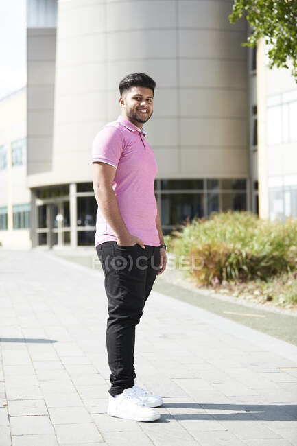 Portrait confident young man outside sunny building — Stock Photo