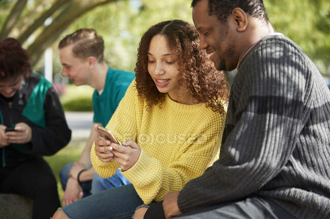 College student friends using smart phone — Stock Photo