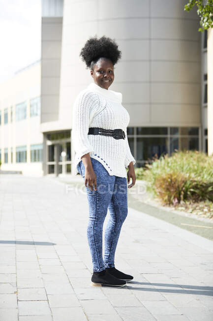 Portrait confident young woman outside sunny building — Stock Photo