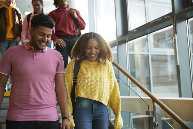 Estudiantes universitarios sonrientes bajando escaleras - foto de stock