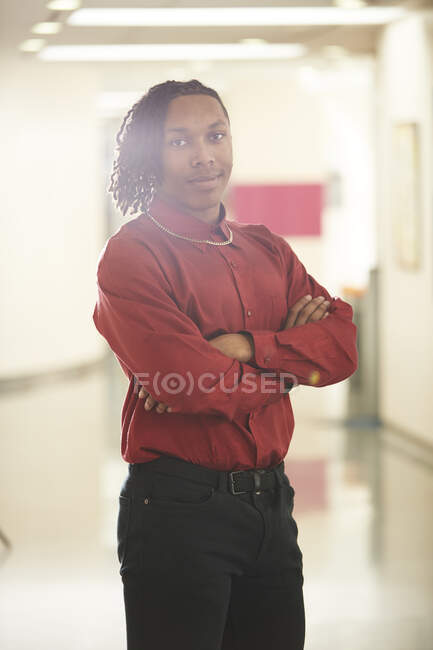 Retrato confiante jovem estudante universitário no corredor — Fotografia de Stock