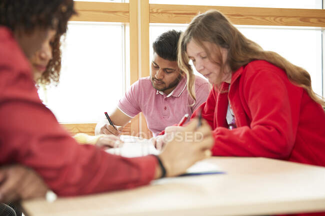 Estudiantes universitarios enfocados estudiando en el aula - foto de stock