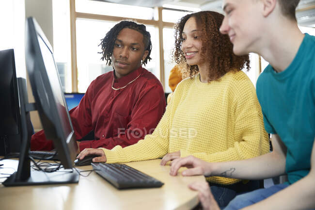 Estudantes universitários usando o computador na biblioteca — Fotografia de Stock