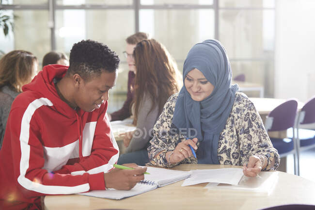Jovens estudantes universitários estudando juntos em sala de aula — Fotografia de Stock