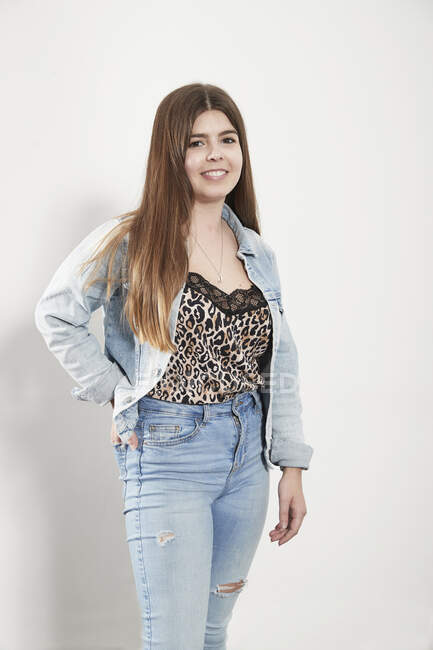 Portrait confiant jeune femme portant une veste en denim et un jean — Photo de stock