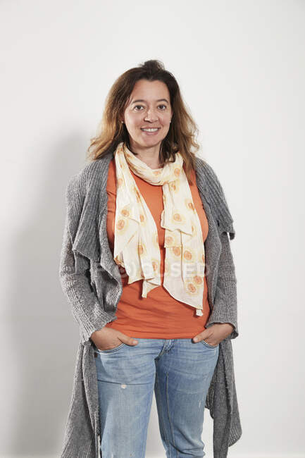 Retrato confiado mujer usando bufanda suéter y jeans - foto de stock