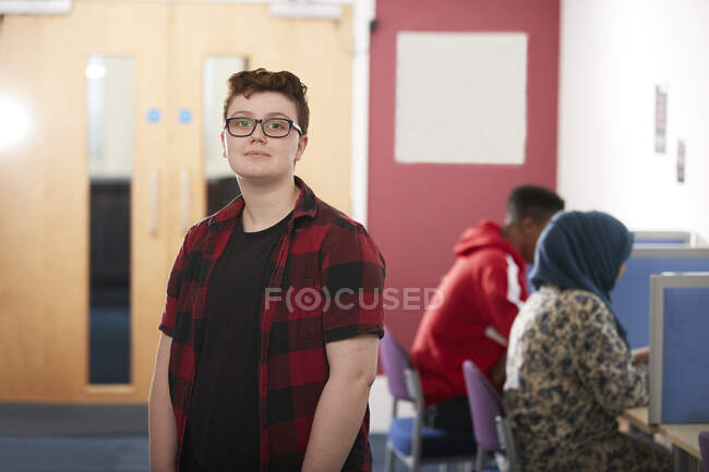 Portrait confident ambitious young male college student in library — Stock Photo