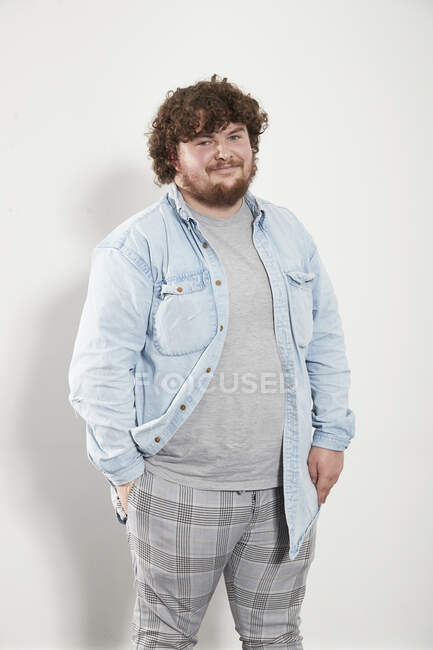 Portrait smiling young man in denim shirt and plaid pants — Stock Photo
