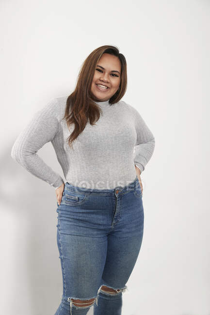 Портрет уверенной молодой женщины в свитере и джинсах — стоковое фото