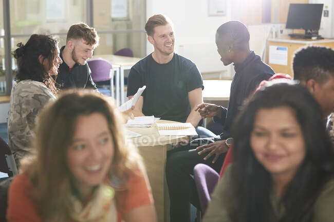 College students studying and talking in sunny classroom — Stock Photo